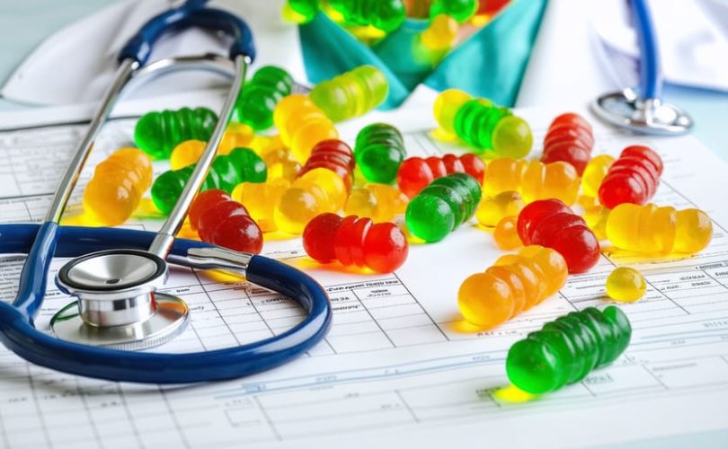 Conceptual portrayal of a medical resident surrounded by colorful CBD gummies, symbolizing focus and stress relief benefits during residency.